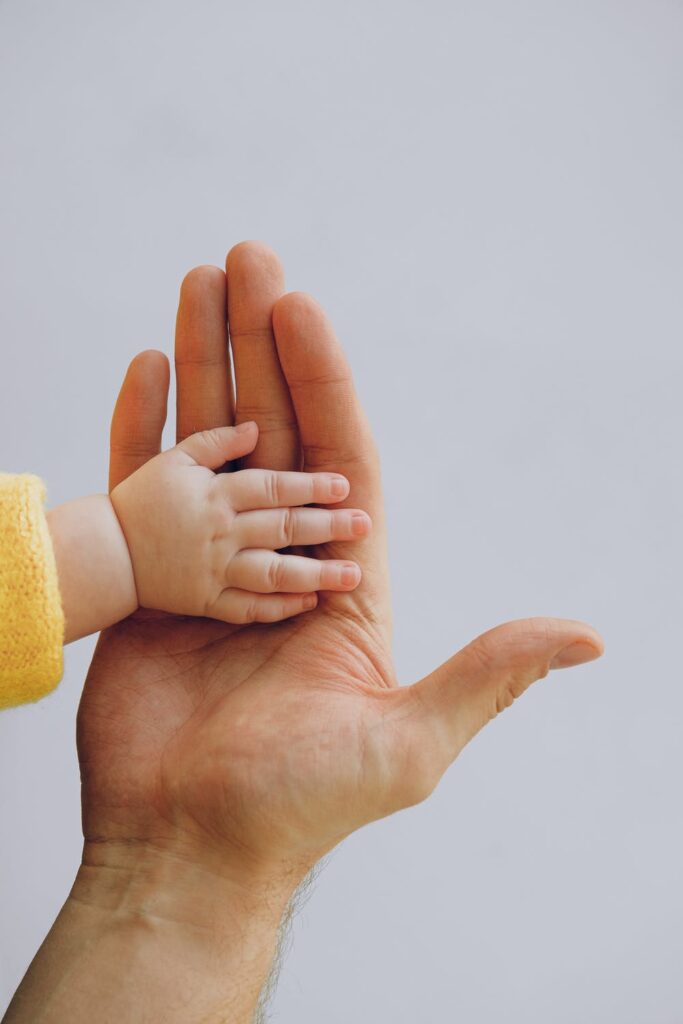 Image of a baby's hand on an adult's palm